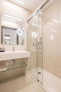 a bathroom with a shower, sink, and mirror at Hotel MeraPrime Gold Lisboa in Lisbon