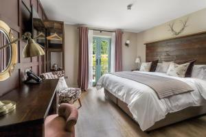 a bedroom with a large bed and a desk with a lamp at The Duke on The Test in Romsey