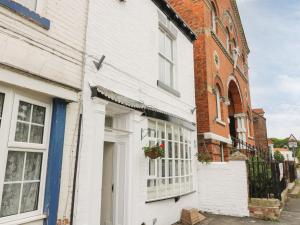 un edificio blanco con una ventana en una calle en The Pebbles, en Hornsea