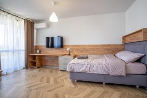 Amarant Aparts في صوفيا: غرفة نوم مع سرير وتلفزيون على الحائط