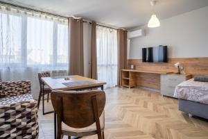 Habitación con mesa, cama y TV. en Amarant Aparts en Sofía
