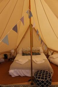 a bedroom with a tent with a bed in it at Gresham Hall Glamping in Aylmerton +38 photos