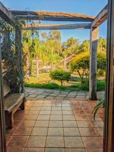 an open door to a patio with a bench at Vila Ventura Ecoresort in Viamão