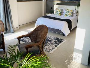 a bedroom with a bed and a chair at 46 on Allcock Guest Apartment & Luxury Room in Pretoria