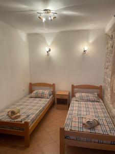 2 łóżka pojedyncze w pokoju z 2 stołami w obiekcie Cozy Little House Kotor w Kotorze