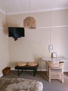 een woonkamer met een tafel en een televisie bij Ebony Moon in Mthatha