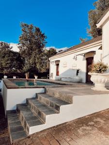 een zwembad met trappen naast een huis bij Ebony Moon in Mthatha
