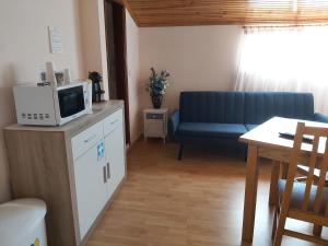 a living room with a blue couch and a table at Encosta da Serra in Sabugueiro