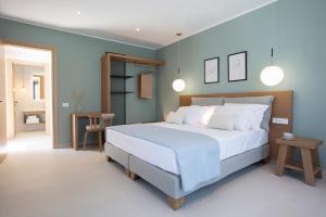 a bedroom with a large white bed with blue walls at villa-agrielia in Nikiana