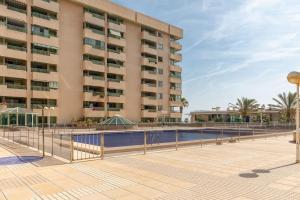 un hotel con piscina frente a un edificio en ApartUP Patacona Beach I, en Valencia