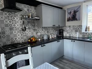 a kitchen with white cabinets and black and white tiles at The nook 21a mill street in Kington