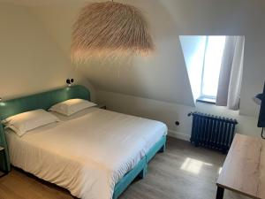 een slaapkamer met een bed met een groen hoofdeinde bij Grand Hôtel de Bretagne in Le Palais
