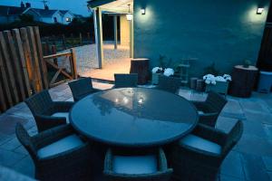 un patio con mesa y sillas en un patio trasero en The Stables Hideaway en Llanelli