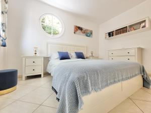 - une chambre blanche avec un grand lit et des oreillers bleus dans l'établissement Blue Coast Bellavista, à Puerto de la Cruz