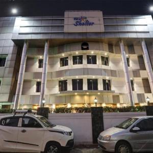 twee auto's geparkeerd voor een gebouw 's nachts bij SHELTER HOTEL in Lucknow