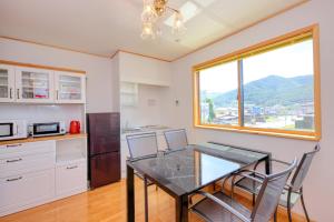富士吉田的住宿－赤富士亭，厨房配有桌椅和窗户。