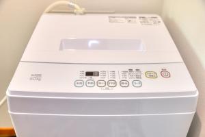 a white washing machine sitting next to a wall at 赤富士亭 in Fujiyoshida