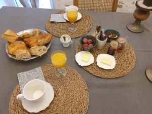 - une table avec petit-déjeuner composé de pain et de jus d'orange dans l'établissement Chambre de charme dans une propriété du 18ème, à Roquettes
