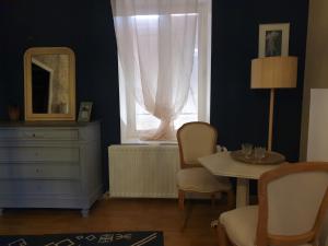 Cette chambre comprend une commode, une table et une fenêtre. dans l'établissement Chambre de charme dans une propriété du 18ème, à Roquettes