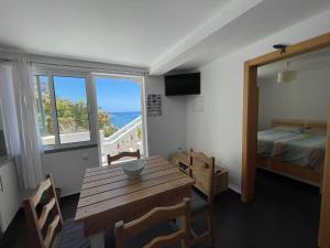 a room with a table and a bed and a window at maktub sunset property in Paul do Mar