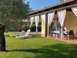 a patio with chairs and a table and a house at Villa Mimosa Tropea in Ricadi