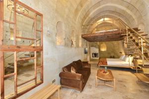 a bedroom with a bunk bed and a couch in a room at Evanthia Cave Suites in Ürgüp