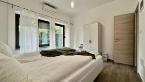 a white bedroom with a large bed and a window at Panorama rooms in Bovec