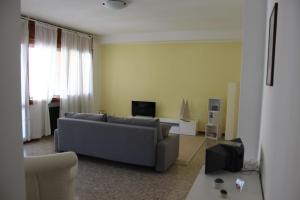a living room with a couch and a tv at APPARTAMENTO AMPIO E LUMINOSO LAGO D'ORTA in San Maurizio dʼOpaglio