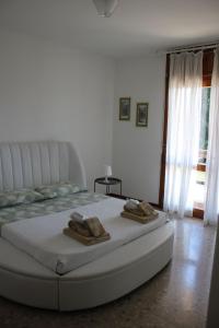 una camera da letto con un letto e due asciugamani di APPARTAMENTO AMPIO E LUMINOSO LAGO D'ORTA a San Maurizio dʼOpaglio