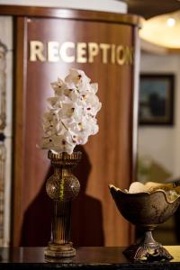 a vase of flowers sitting on top of a table at Park Hotel Sankt Peterburg in Plovdiv