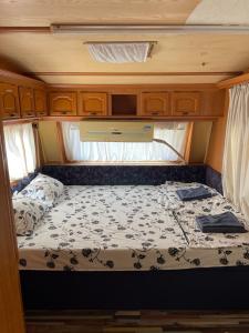 una cama en la parte trasera de una caravana en SEA CARAVAN ON THE BEACH en Kiten