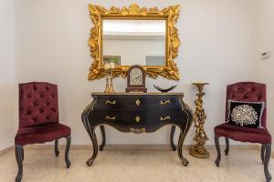 einen Schminktisch mit einem Spiegel und 2 Stühlen in der Unterkunft Ginevra Luxury New Classic Apartment close Vatican in Rom