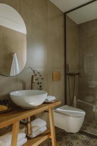 a bathroom with a sink and a toilet and a mirror at BATU Luxury Apartments in Preveza