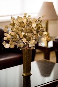 プロブディフにあるPark Hotel Sankt Peterburgのテーブルの上に金の花を飾った花瓶