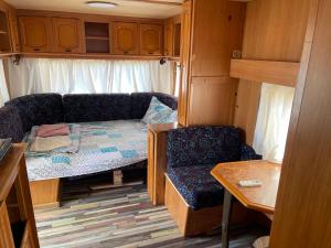 a small room with a couch and a chair in a rv at SEA CARAVAN ON THE BEACH in Kiten