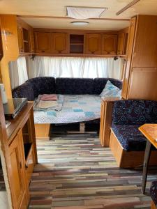 Habitación pequeña con sofá y cama en una cabaña en SEA CARAVAN ON THE BEACH en Kiten