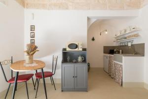 a kitchen and dining room with a table and chairs at Cementine Traditional Suites by Wonderful Italy in Ostuni