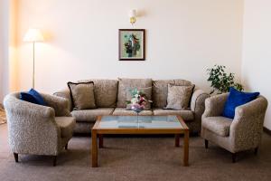 ein Wohnzimmer mit einem Sofa, 2 Stühlen und einem Couchtisch in der Unterkunft Park Hotel Sankt Peterburg in Plowdiw + 75 Fotos