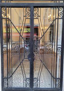 uma porta para uma loja com um portão de ferro forjado em Superbe studio meublé cosy avec patio au calme Jean médecin em Nice