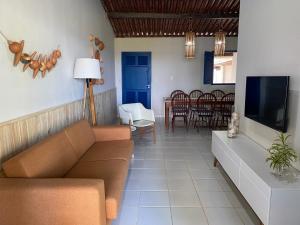 een woonkamer met een bank en een tv bij Casa beira mar, 4 quartos - Sanzé - Maragogi/AL in São José da Coroa Grande