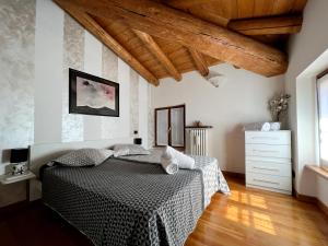 una camera con 2 letti e un soffitto in legno di Casa Cele a Garda