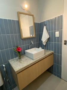 ein Bad mit einem Waschbecken und einem Spiegel in der Unterkunft Casa beira mar, 4 quartos - Sanzé - Maragogi/AL in São José da Coroa Grande