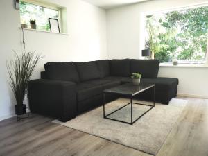 a living room with a black couch and a table at Landvetter Apartment in Landvetter