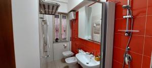 ein Badezimmer mit einem weißen Waschbecken und einem WC in der Unterkunft Lincoln B&B in Caserta