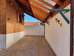 an empty garage with a wooden ceiling and a brick wall at Chalé Sonho Meu in Monte Verde