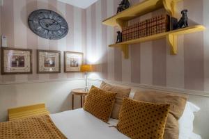 パリにあるホテル ドゥ ラヴルのベッドルーム1室(ベッド1台、壁掛け時計付)