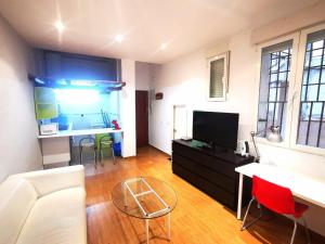 a living room with a white couch and a tv at Apartamento Malasaña II in Madrid