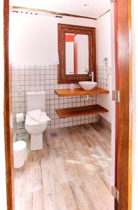 ein Badezimmer mit einem WC, einem Waschbecken und einem Spiegel in der Unterkunft Casa Formosa Baleia in São Sebastião