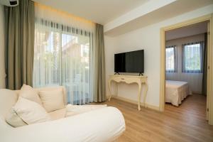 a living room with a white couch and a television at Channel Suites in Fethiye