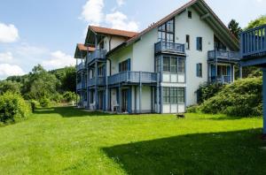 uma grande casa branca com um grande quintal em Ferienland Sonnenwald Fewo 46 und Studio 50 in Schöfweg Bayerischer Wald em Schöfweg